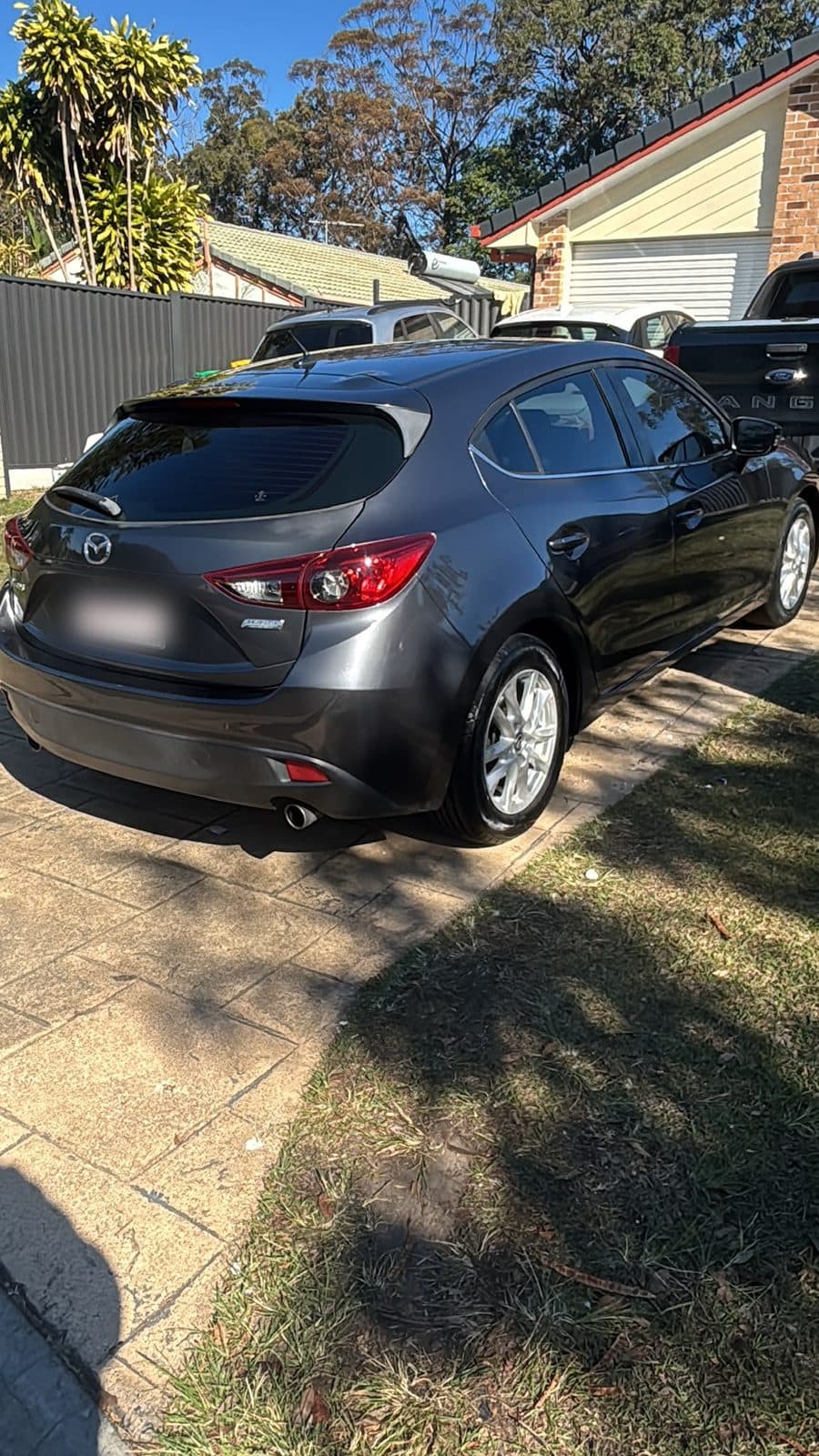 Dark grey 2013 Mazda 3 hatchback parked beside a lawn, photo 2